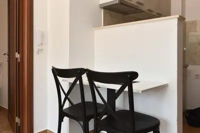 a black chair sitting next to a white desk at Omega 1 Apartment Budva in Budva