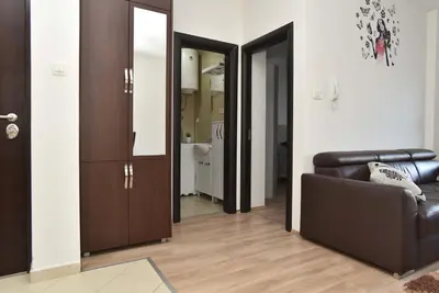 a living room with a leather couch and a mirror at Omega 2 Apartment Budva in Budva