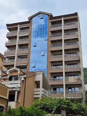 an apartment building with a blue glass facade at Omega 2 Apartment Budva in Budva