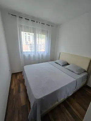 a bed in a white room with a window at Omega 3 Apartment Budva in Budva