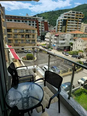 a balcony with a table and chairs and a view of a city at Omega 3 Apartment Budva in Budva