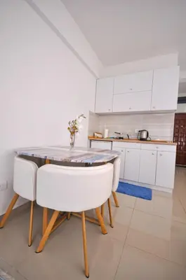 a kitchen with white cabinets and a table and chairs at DaSU 1 CENTAR in Bar