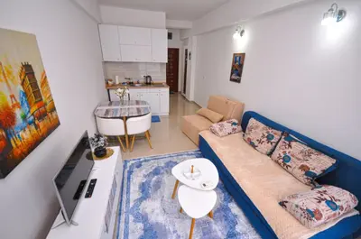 a living room with a blue couch and a kitchen at DaSU 1 CENTAR in Bar