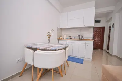 a kitchen with a table and some white cabinets at DaSU 1 CENTAR in Bar