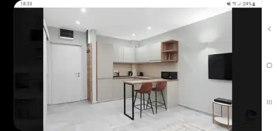 a kitchen with white cabinets and bar stools at LucaSa Apartment in Kotor