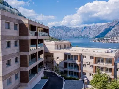an apartment building with a view of a lake and mountains at LucaSa Apartment in Kotor