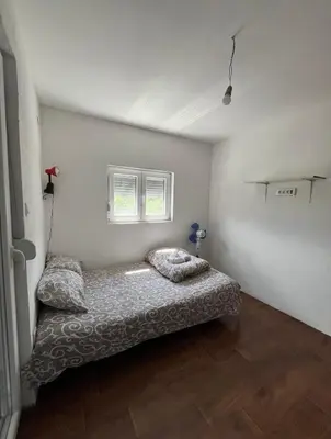 a bedroom with a bed in the corner of a room at APARTMENTS Mir in Virpazar