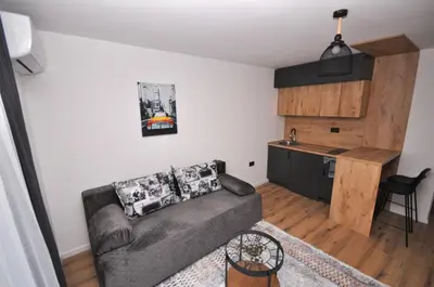 a living room with a couch and a kitchen at Studio Dobra Voda 14 in Bar