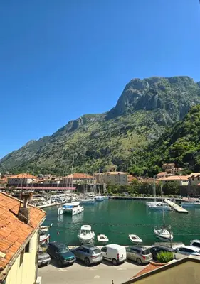 a bunch of boats in a harbor with a mountain at The Queen of Boka in Kotor