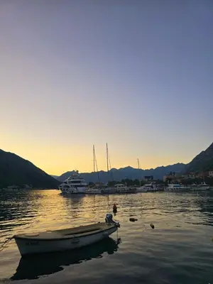 a small boat sitting in the water at sunset at The Queen of Boka in Kotor