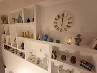 a room with shelves filled with vases and a clock at The Queen of Boka in Kotor