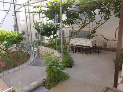 a patio with a table and chairs in a greenhouse at Kiwi in Ulcinj