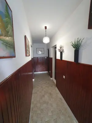 a hallway with wood paneling and a hallway with plants on the walls at Kiwi in Ulcinj