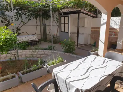 a patio with a table and some plants in a garden at Kiwi in Ulcinj
