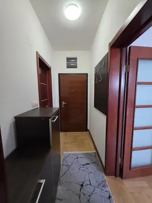 a kitchen with a refrigerator and a wooden door at G apartment city centre Budva in Budva