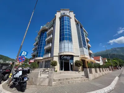 a building with a motorcycle parked in front of it at G apartment city centre Budva in Budva