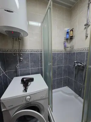 a bathroom with a washing machine and a shower at G apartment city centre Budva in Budva