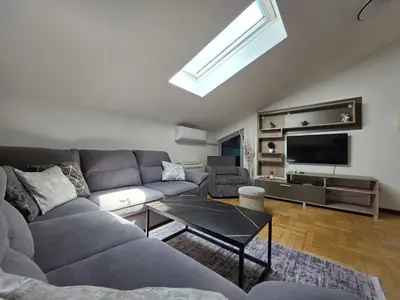 a living room with a couch and a tv at G apartment city centre Budva in Budva