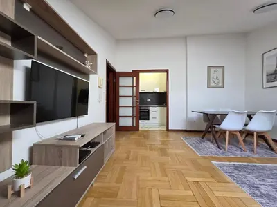 a living room with a large television and a table at G apartment city centre Budva in Budva