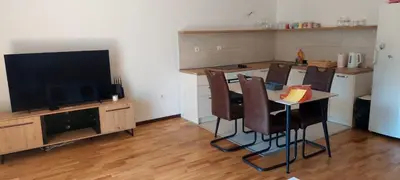 a kitchen with a table and chairs and a television at Seaside Milena Appartment in Budva