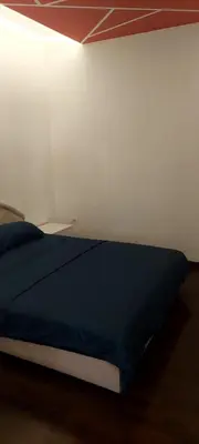 a bedroom with a blue bed in a white wall at Seaside Milena Appartment in Budva
