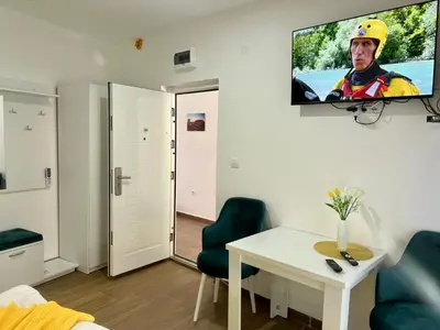 a living room with a tv hanging on a wall at Kangaroo Apartmani in Prijevor