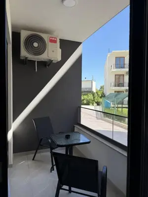 a room with a table and a fan and a window at Morning star in Ulcinj