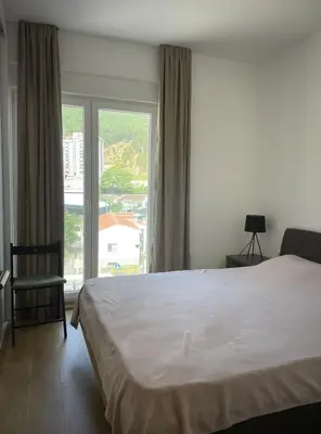 a bedroom with a bed and a large window at TehnomaX in Budva