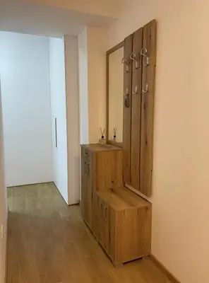 a dressing room with a wooden cabinet and a mirror at TehnomaX in Budva