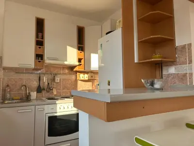 a kitchen with white appliances and wooden cabinets at Green square apartment Budva in Budva
