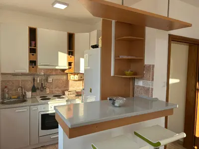 a kitchen with white cabinets and a white refrigerator at Green square apartment Budva in Budva
