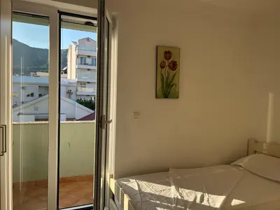 a room with a bed and a picture on the wall at Green square apartment Budva in Budva