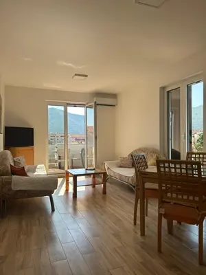 a living room with a couch and a table at Green square apartment Budva in Budva