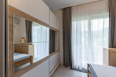 a bedroom with a large mirror and a window at Jasmine 2-bedroom apartment in Becici