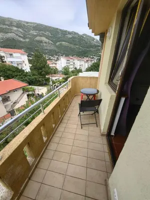 a balcony with a table and a chair on it at Cozy duplex in Sutomore in Sutomore