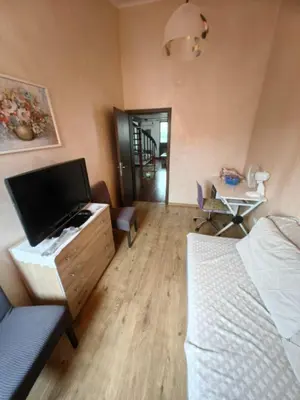 a living room with a tv and a bed and a table at Cozy duplex in Sutomore in Sutomore