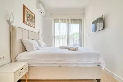 a white bedroom with a large bed and a window at Twin Towers LT Luxury in Becici
