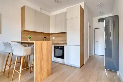 a kitchen with white cabinets and a counter with chairs at Twin Towers LT Luxury in Becici