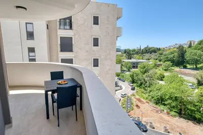 a table on a balcony with a view of a building at Twin Towers LT Luxury in Becici