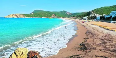 a beach with a group of people and the ocean at Apartmani Čanj in Čanj