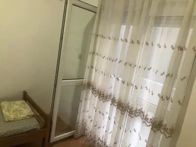 a bedroom with a shower curtain and a window at Apartmani Čanj in Čanj