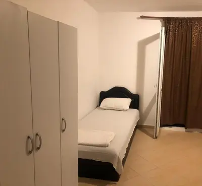 a small bedroom with a bed and a cabinet at Apartmani Čanj in Čanj