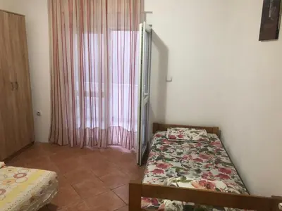 a bedroom with two beds and a window at Apartmani Čanj in Čanj