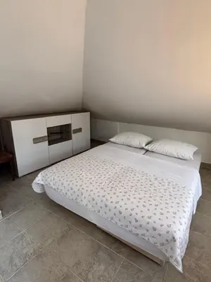 a bedroom with a white bed with two pillows at Little Stone House in Utjeha