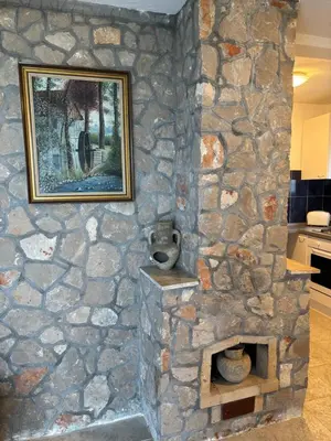 a stone fireplace with a picture on the wall at Little Stone House in Utjeha