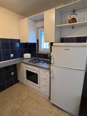 a kitchen with white appliances and a white refrigerator at Little Stone House in Utjeha