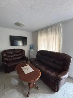 a living room with two leather couches and a coffee table at Little Stone House in Utjeha