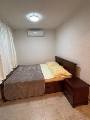a small bedroom with a bed and a night stand at Little Stone House in Utjeha