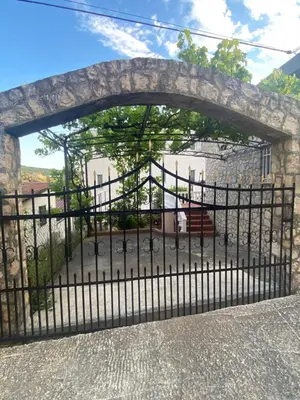a black iron gate with a stone bridge at Little Stone House in Utjeha