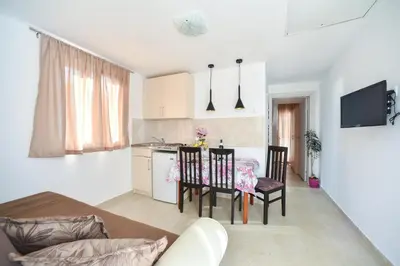 a kitchen and dining room with a table and chairs at Apartmani Bonik in Budva